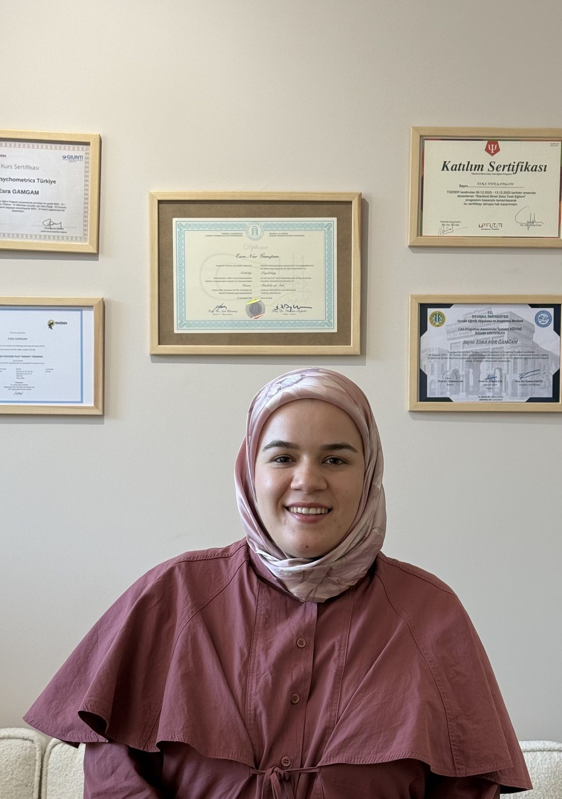 Esra Gamgam Gökdemir eğitim sertifikalarının önünde